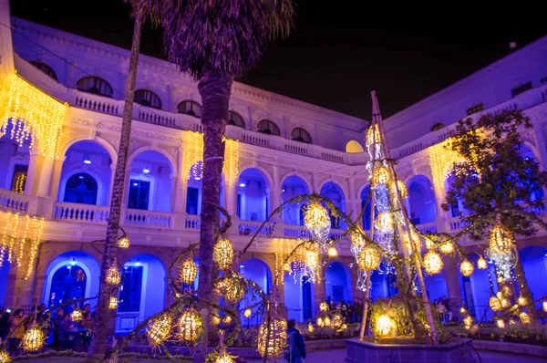 QUITO, ECUADOR- 15 AGOSTO 2018: Vista interna di persone che scattano foto all'interno dell'edificio coloniale con luci colorate durante il festival della luce di Quito — Foto Stock