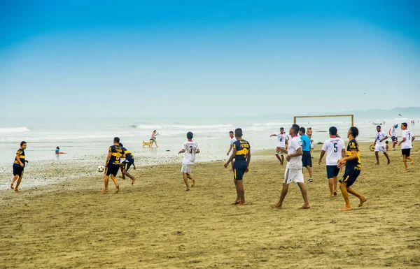 Manabi, Equador, 29 de maio de 2018: Aproveitando o tempo com os melhores amigos. Grupo de jovens alegres que jogam com bola de futebol na praia com o mar no fundo — Fotografia de Stock