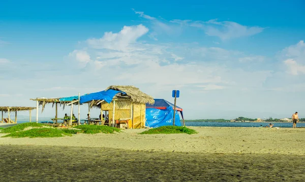 MANABI, ECUADOR, MAIO, 29, 2018 Vista ao ar livre de pessoas não identificadas sob uma estrutura de cabana feita de palha na costa da praia em Cojimies — Fotografia de Stock