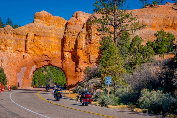 BRYCE CANYON, UTAH, JUNE, 07, 2018: Outdoor view of motorcyclists in the road crossing throught the red arch road tunnel on the way to Bryce Canyon National Park, Utah — Stock Photo, Image