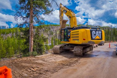 Yellowstone Milli Parkı, Wyoming, Amerika Birleşik Devletleri - 07 Haziran 2018: Açık bir yol inşaat muhteşem bir gün boyunca toprak kaldırma kamyon görünümünü. Yol çalışması Yellowstone Milli Parkı'nda