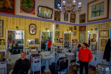 SANTIAGO, CHILE - SEPTEMBER 13, 2018: Indoor view of people inside of a hair salon in Barrio Yungay in Santiago clipart