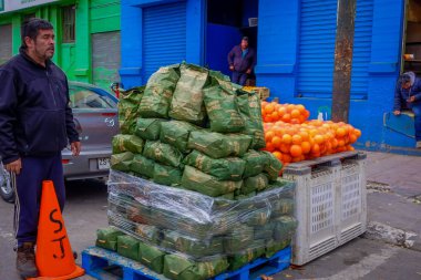 Valparaiso, Şili - Eylül, 15, 2018: Tanımlanamayan adam keseleri kömürler ve meyve Valparaiso, Şili'deki tarihi pazar yanında bir sokakta yığını ile