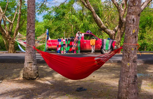 Samara, Costa Rica, June, 26, 2018: Outdoor view of hammock between trees with a red car in the background sellying colorful and beautififul hammock at Samara beach in Costa Rica — Stock Photo, Image