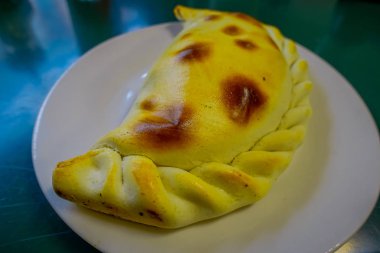 Jambon ve peynir ile doldurulmuş pasta pişmiş Şili Empanadas ile doğal ışık beyaz bir plaka üzerinde fotoğraflandı.