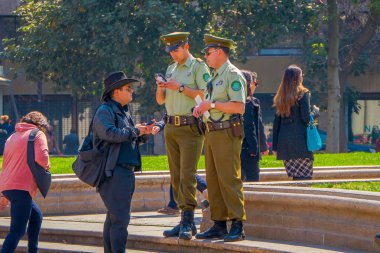 Santiago, Şili - 13 Eylül 2018: İki la Moneda Sarayı, Santiago de Chile Cumhurbaşkanı koltuğunda önünde birine bilgi veren carabineros olarak adlandırılan polis.