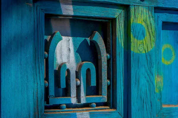 Fechar o foco seletivo da estrutura metálica em uma porta de madeira localizada no bairro Yungay em Santiago, capital do Chile — Fotografia de Stock