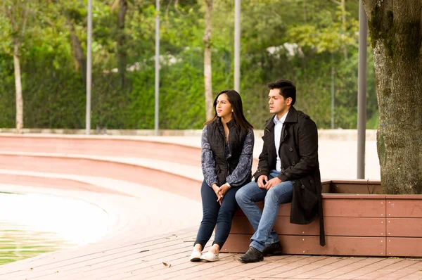 Красивая молодая пара влюблена в день Святого Валентина, сидящая в парке — стоковое фото