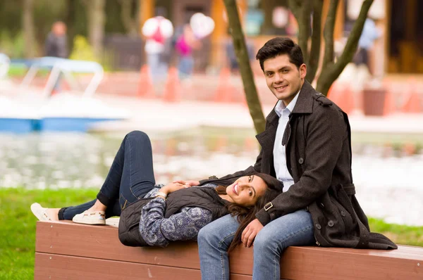 Hermosa joven pareja enamorada en San Valentín día, mujer reclinada en sus piernas novio, en el parque — Foto de Stock