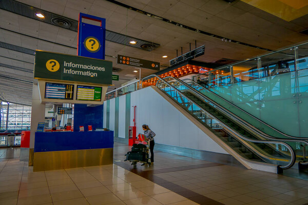 САНТЬЯГО, ЧИЛЬ - 13 СЕНТЯБРЯ 2018 г.: Неизвестные люди, входящие в аэропорт и переходящие вблизи электрической лестницы в городе Сантьяго
