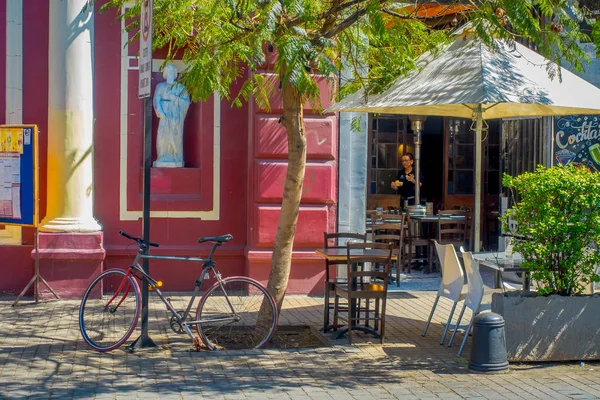 SANTIAGO, CHILE - 13 DE SEPTIEMBRE DE 2018: Vista exterior de la fachada de un restaurante con sillas, mesa y sombrilla, y bicicleta aparcada cerca del barrio Lastarria en Santiago de Chile — Foto de Stock