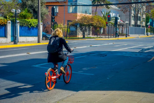 SANTIAGO, CHILE - 13 DE SEPTIEMBRE DE 2018: Mujer no identificada que pedalea su bicicleta de alquiler en la ciudad durante un hermoso día soleado en el centro de la ciudad de Santiago — Foto de Stock