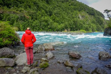 Puerto Varas, Şili, Eylül, 23, 2018: kırmızı ceket ve nehre Saltos de Petrohue Şili, volkanik eylem tarafından kurulan Güney zevk tek turist adam