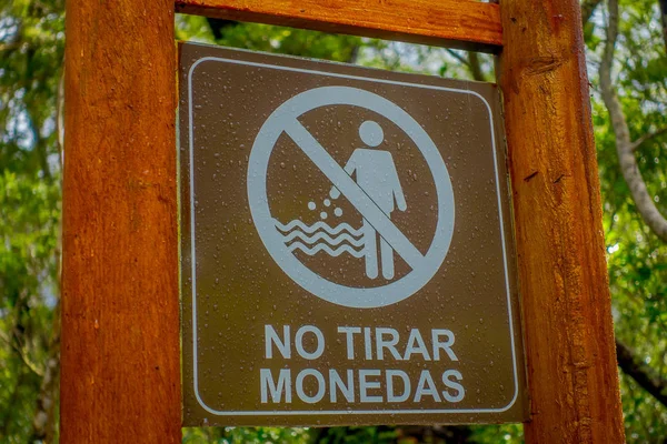 PUERTO VARAS, CHILE, SEPTEMBER, 23, 2018: Outdoor view of informative sign of do throw coins to the river Petrohue in wooden structure in Vicente Perez Rosales park in Chile — Stock Photo, Image