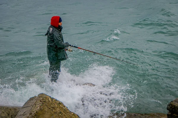 PUERTO VARAS, CHILE, 23 DE SEPTIEMBRE DE 2018: Pescador no identificado parado en una roca con caña de pescar en patagonia chilena — Foto de Stock