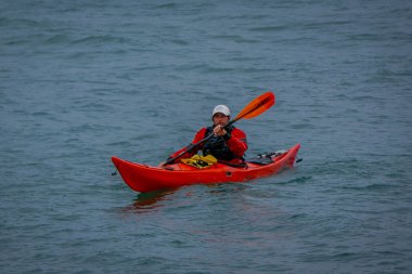 Puerto Varas, Şili, Eylül, 23, 2018: Turuncu kayık Puerto Varas Şili suda gün zevk tanımlanamayan adam