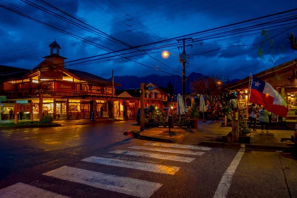 PUCON, CHILE - 23 DE SEPTIEMBRE DE 2018: Hermosa vista al aire libre del turista caminando por las calles de la ciudad en Pucón durante la noche rodeando de magníficos edificios de madera — Foto de Stock