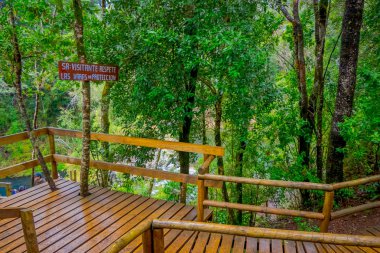 Pucon, Şili - 23 Eylül 2018: Açık şelaleler Pucon, Şili, ahşap bir frences ile yakın ahşap bilgilendirici işareti görünümünü