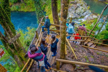 Pucon, Şili - 23 Eylül 2018: Pucon, Şili şelaleler ile bazı ahşap çit her yakın yürüyüş turist görünümünü yukarıda yan