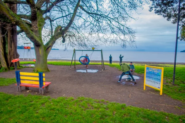 Frutillar, Chile - September 23, 2018: Utomhus suddig syn på personer som spelar i blayground på en strand i Frutillar byn, Chile — Stockfoto