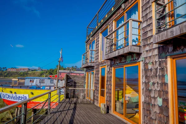 CHILOE, CHILI - 27 SEPTEMBRE 2018 : Vue du magnifique restaurant en bois coloré cebiche sur pilotis palafitos, dans une maison en bois à marée basse de couleur jaune et rouge à la journée ensoleillée à Castro, Chili — Photo