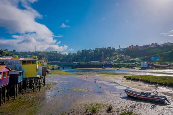 CHILOE, CHILE - SEPTEMBER, 27, 2018: Above view of single boat next to wooden buildings on stilts palafitos in Castro, Chiloe Island, Patagonia — Stock Photo, Image