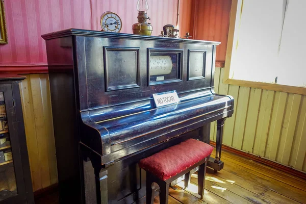 Chonchi (Chili), September, 27, 2018: Indoor weergave van zwarte piano binnenkant museum van chonchi gevuld met meubelen en ornamenten uit de jaren 1920, geschonken door families van Chonchi, geopend in 1996 — Stockfoto