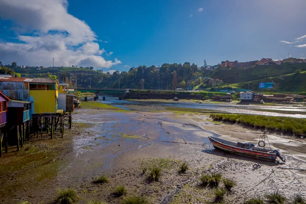 CHILOE, CHILE - SEPTEMBER, 27, 2018: Above view of single boat next to wooden buildings on stilts palafitos in Castro, Chiloe Island, Patagonia — Stock Photo, Image