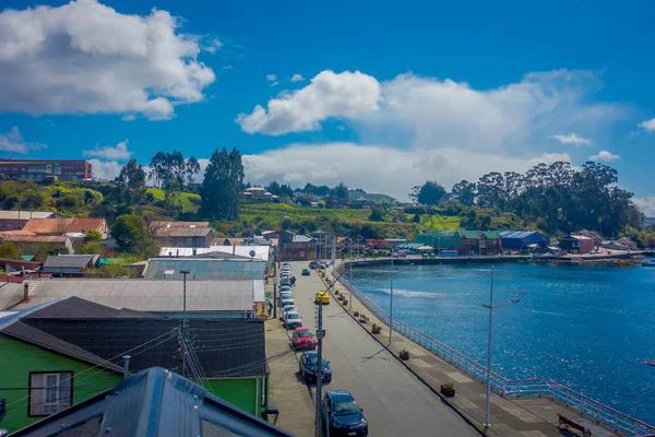 Chiloe, Şili - Eylül, 27, 2018: Chiloe islandm limanda muhteşem chonchi önünde sokakta park edilmiş araba görünümünü yukarıda güzel ahşap çevreleyen Şili'evler — Stok fotoğraf