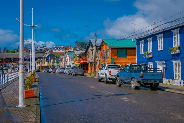 CHILOE, CHILE - 27 DE SEPTIEMBRE DE 2018: Vista al aire libre de algunos coches estacionados en la calle frente al magnífico puerto de chonchi en la isla de Chiloé rodeada de hermosas casas de madera en Chile — Foto de Stock