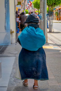 Otavalo şehir sGeçerli kaldırımda yürüyen yerli kadın arkadan görünüm