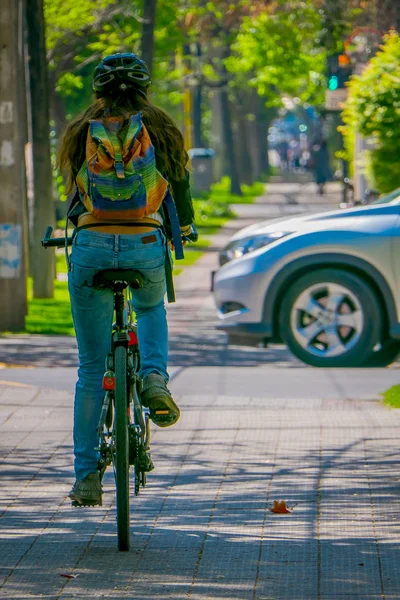 SANTIAGO, CHILE - 13 DE SEPTIEMBRE DE 2018: Vista trasera de una mujer no identificada que pedalea su bicicleta de alquiler en la ciudad durante un hermoso día soleado en el centro de la ciudad de Santiago — Foto de Stock