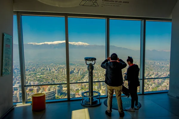 SANTIAGO, CHILE - OUTUBRO 16, 2018: Vista interior do casal que está perto de uma máquina de visualização de moedas com a cidade de Santiago, no monte San Cristobal, os Andes que se estendem através da horizontal — Fotografia de Stock