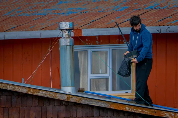 CHILOE, CHILE - SEPTEMBER, 27, 2018: Unidentified man cleanning his house on stilts palafitos in Castro, Chiloe Island, Patagonia — Stock Photo, Image