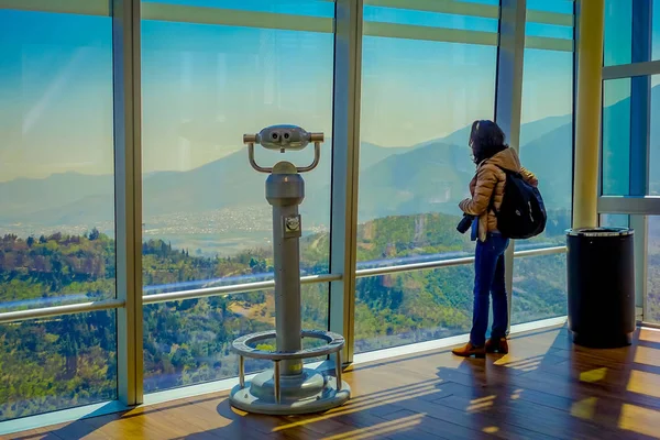 Santiago, Chile - október 16, 2018: Nő állandó közel egy érme viewer gép-val a Santiago város, San Cristobal Hill, az Andok-hegység nyúlik át a horizont — Stock Fotó
