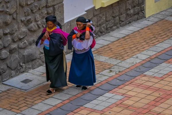 COTACACHI, ECUADOR, 06 DE NOVIEMBRE DE 2018: Vista al aire libre de dos mujeres indígenas caminando juntas por las calles de Cotacachi y sosteniendo en sus maletas de ropa en la ciudad de Cotacachi —  Fotos de Stock