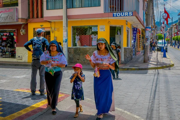 OTAVALO, ECUADOR, 06 DE NOVIEMBRE DE 2018: Familia caminando por las calles de la ciudad de Otavalo vistiendo ropa típica indígena — Foto de Stock
