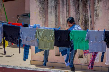 Otavalo, Ekvator, 06 Kasım 2018: Kimliği belirsiz kadın Otavalo güneşte kurutma bir giysi yanında açık görünümü