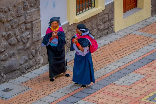 COTACACHI, ÉQUATEUR, 06 NOVEMBRE 2018 : Vue extérieure de deux femmes autochtones marchant ensemble dans les rues de Cotacachi et tenant dans leur sac à dos des vêtements dans la ville de Cotacachi — Photo