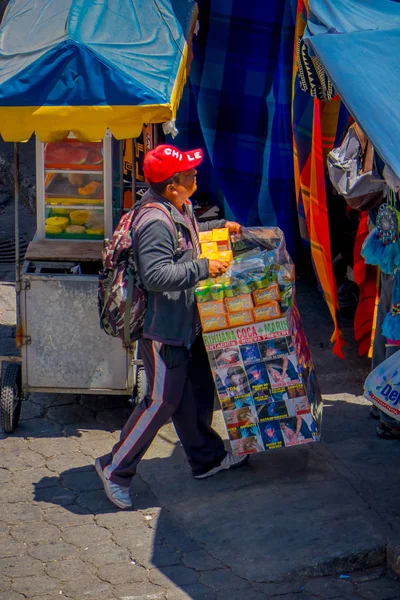 OTAVALO, ECUADOR, NOVEMBRO 06, 2018: Homem não identificado vendendo produtos na rua perto do mercado de rua com roupas típicas em Otavalo — Fotografia de Stock