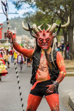 Quito, Ekvator - Seotember, 03, 2018: şeytan ve onun nezarete zıpkın diablada festival sırasında el gibi giyinmiş bir iblis maskeyle kimliği belirsiz adam