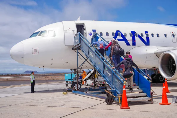 GALAPAGOS, ECUADOR, 25 DE NOVIEMBRE DE 2018: Turistas caminando hacia y abordando un avión Lan en el aeropuerto de Galápagos Ecuador — Foto de Stock