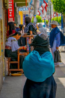 Otavalo şehir sGeçerli kaldırımda yürüyen yerli kadın arkadan görünüm