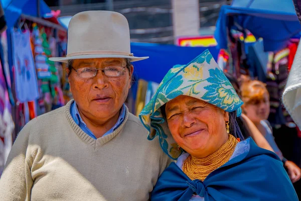 Otavalo, ecuador, november 06, 2018: porträt eines indigenen paares, das auf dem straßenmarkt in otavalo für die kamera posiert und traditionelle andine kleidung trägt — Stockfoto
