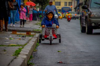 Quito, Ekvator - 21 Ağustos 2018: bir üç tekerlekli bisiklet sepeti, şehir San Juan Quito içinde sokaklarda sürme üzgün çocuk