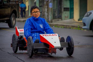 Quito, Ekvator - 21 Ağustos 2018: Bir üç tekerlekli bisiklet sepeti, şehir San Juan Quito içinde sokaklarda sürme gözlük ile mavi ceketli çocuk açık görünüm