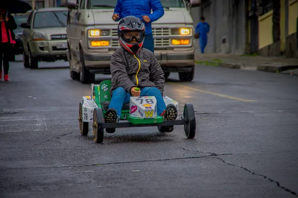 QUITO, ECUADOR - AGOSTO 21, 2018: Fechar um menino não identificado correndo de um carro vermelho de madeira nas ruas da cidade de Quito — Fotografia de Stock