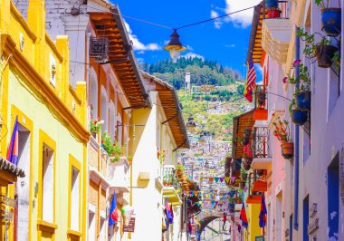 QUITO, ECUADOR AUGUST, 28, 2018: Beautiful buildings with some Flags hanging from a balcony at historical center of old town Quito in northern Ecuador in the Andes mountains clipart