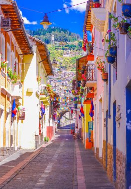 QUITO, ECUADOR AUGUST, 28, 2018: Beautiful buildings with some Flags hanging from a balcony at historical center of old town Quito in northern Ecuador in the Andes mountains clipart