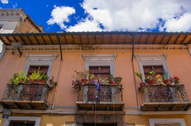 Bazı çiçek ve bir balkon tarihsel asılı bayrakları ile güzel sömürge Binası merkezi eski kasaba Quito Andes Dağları'nda Kuzey Ekvator